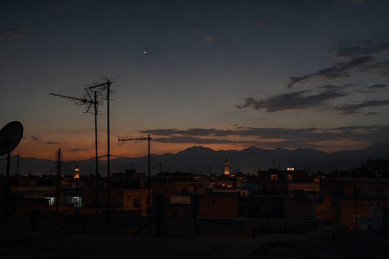 Toits de Marrakech au crépuscule avec les montagnes au loin